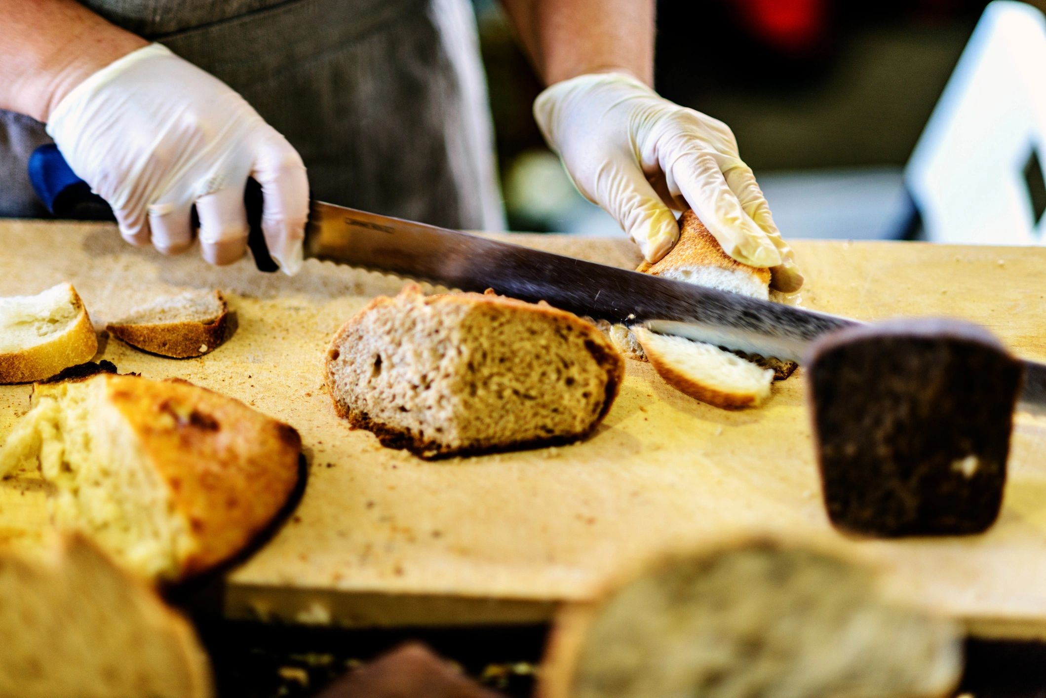 Person slicing bread on a wooden board