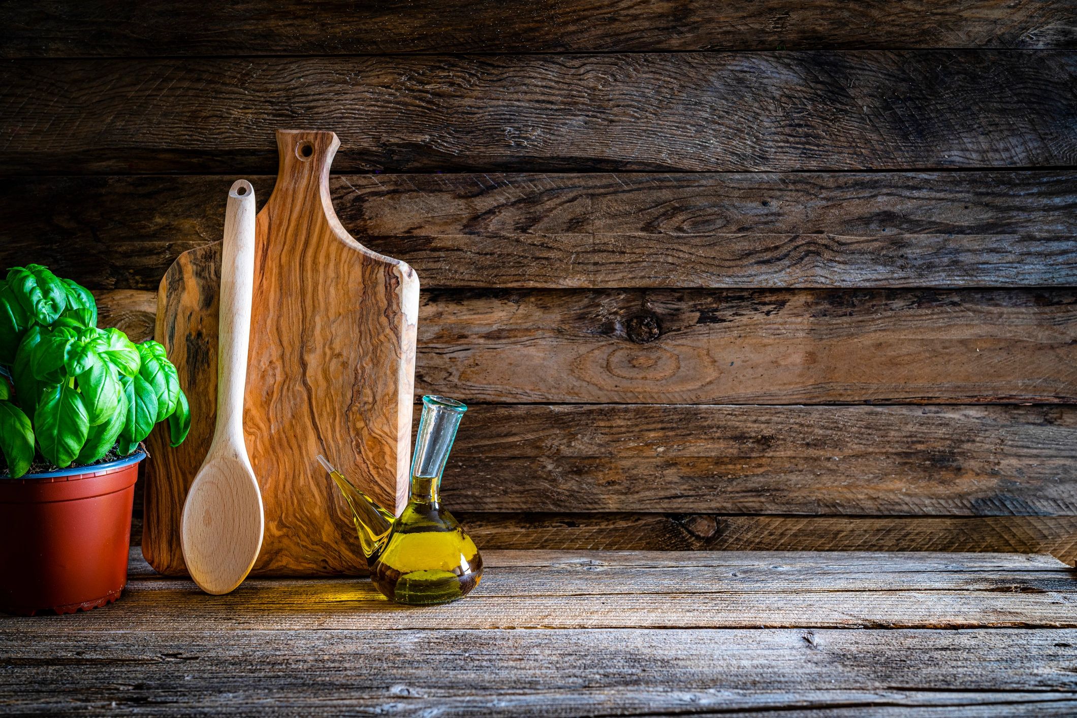 Cutting board and kitchen items on a rustic wooden table with copy space