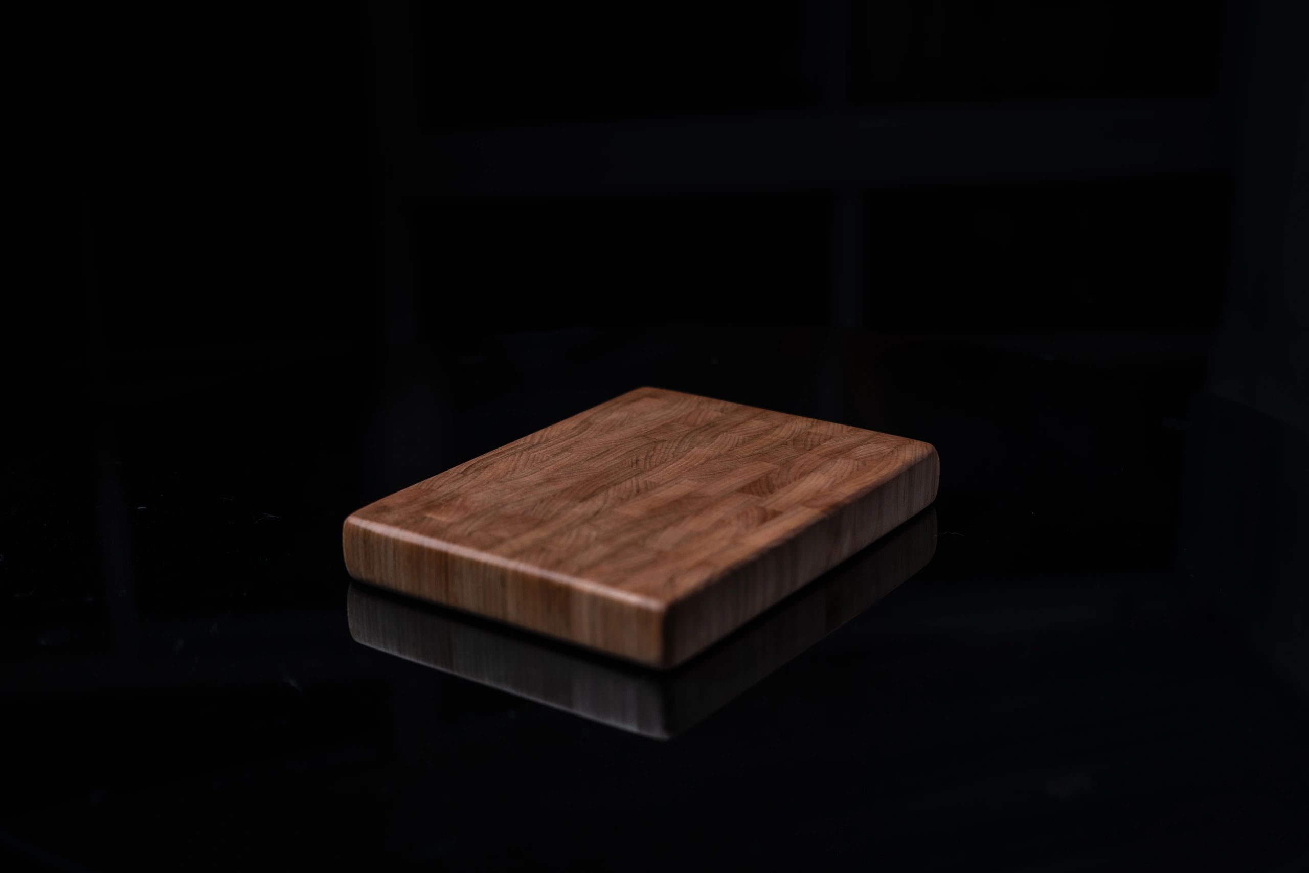 Handmade maple cutting board on a dark background
