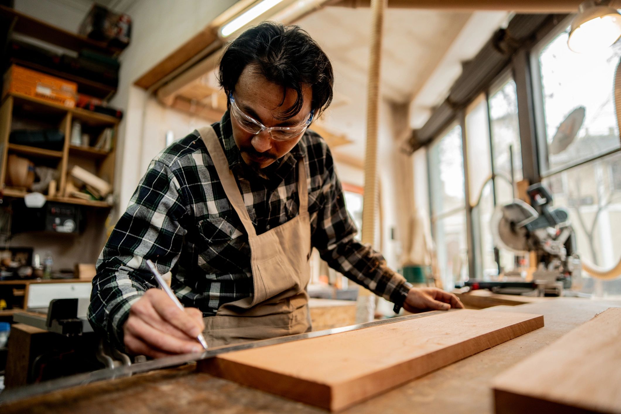 Hands measuring wood in a workshop for a custom project